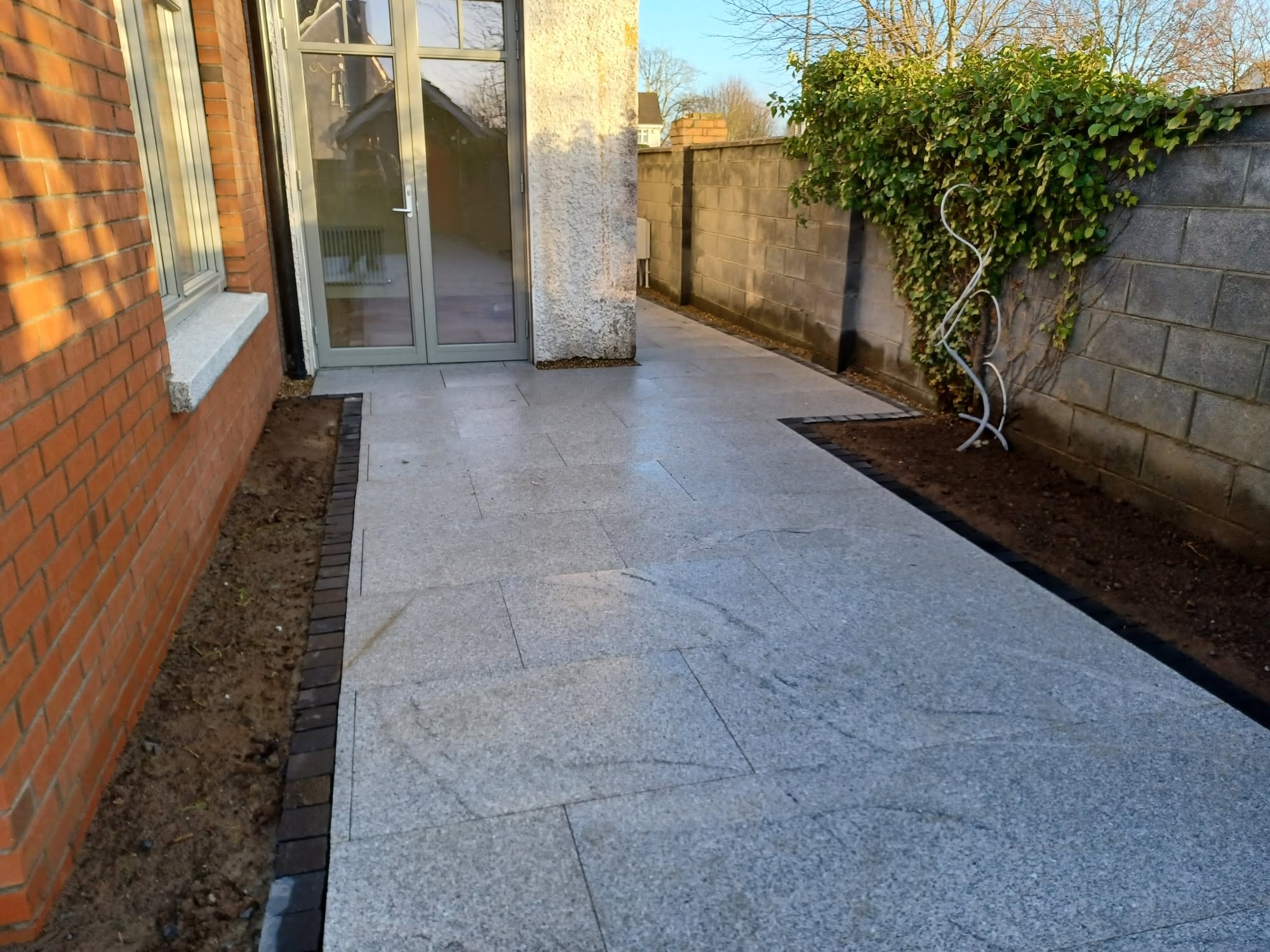 Silver granite paved side path leading to patio doors in Portlaoise